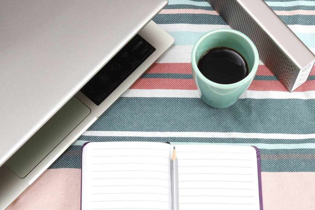 Modern home office or work place with laptop, notebook and coffee, Top view with copy space, flat lay