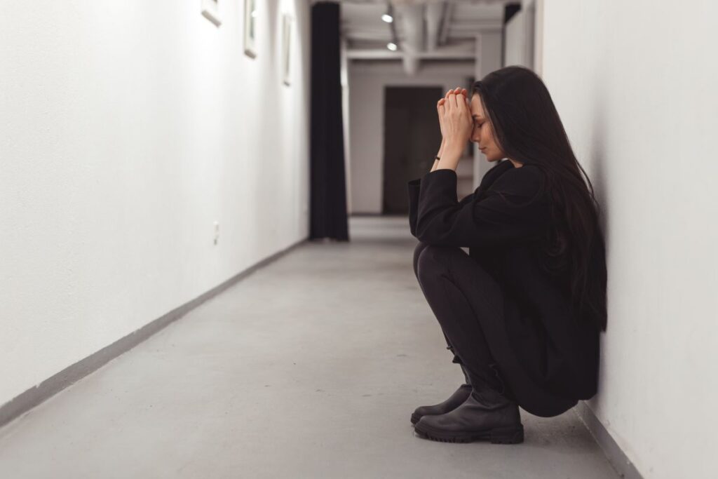 Stressed overworked young business woman sitting on floor. Fired and depressed in office.