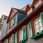 European windows with green wooden shutters in old house. Outdoors exterior