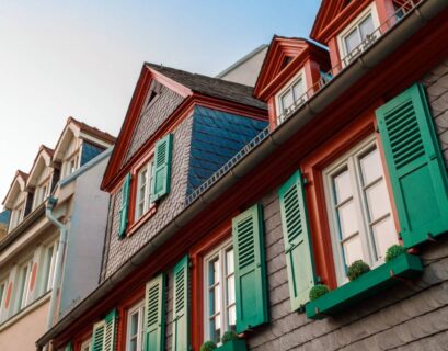 European windows with green wooden shutters in old house. Outdoors exterior