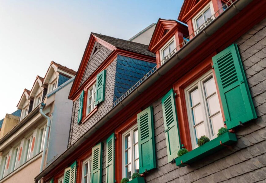 European windows with green wooden shutters in old house. Outdoors exterior