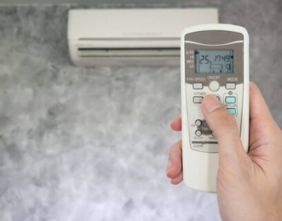 hand holding remote in front of air conditioner 2023 11 27 05 03 07 utc