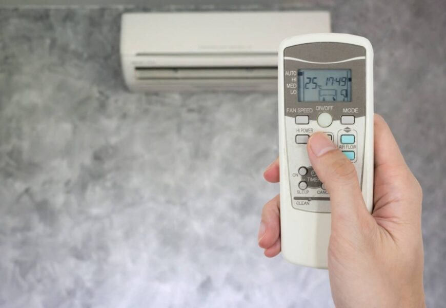 hand holding remote in front of air conditioner 2023 11 27 05 03 07 utc