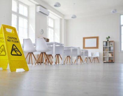 School classroom where cleaning service worker placed sign which reads Caution Wet Floor