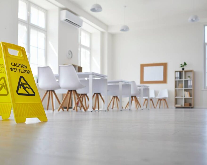 School classroom where cleaning service worker placed sign which reads Caution Wet Floor