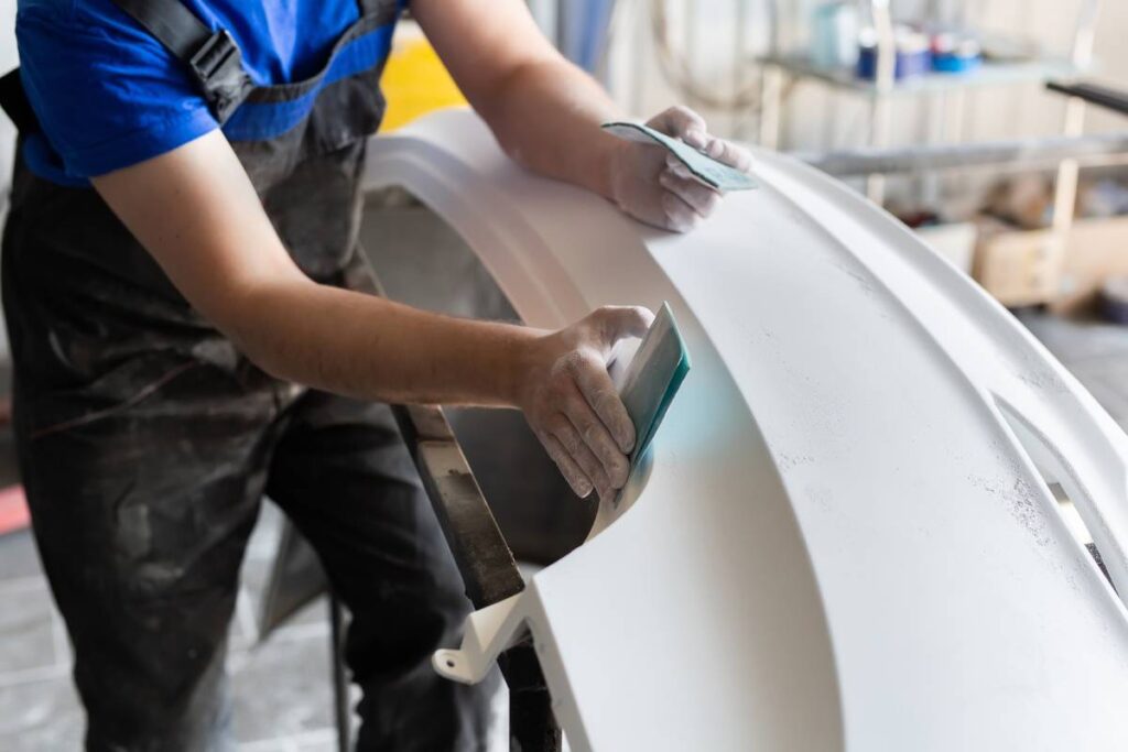 Sanding and polishing the car at the service station with sandpaper before painting