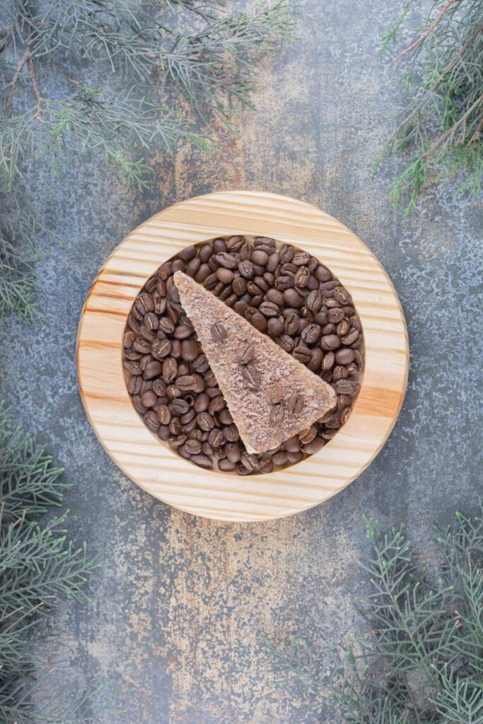 A delicious piece of cake with coffee beans on wooden board