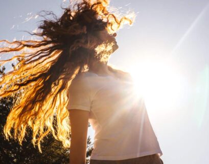 Happy girl with long hair in sunshine.