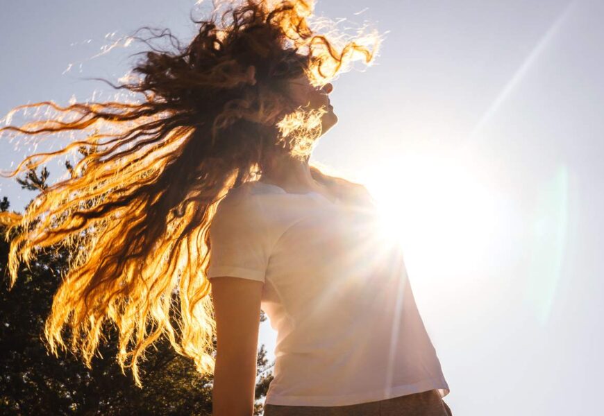 Happy girl with long hair in sunshine.