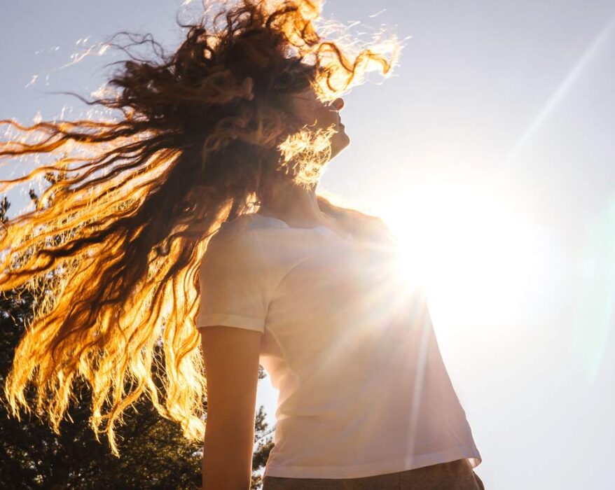 Happy girl with long hair in sunshine.