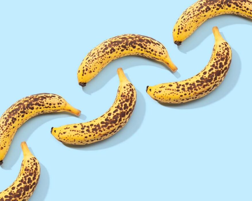 Spotted Banana pattern on blue background. Art food. Copy space