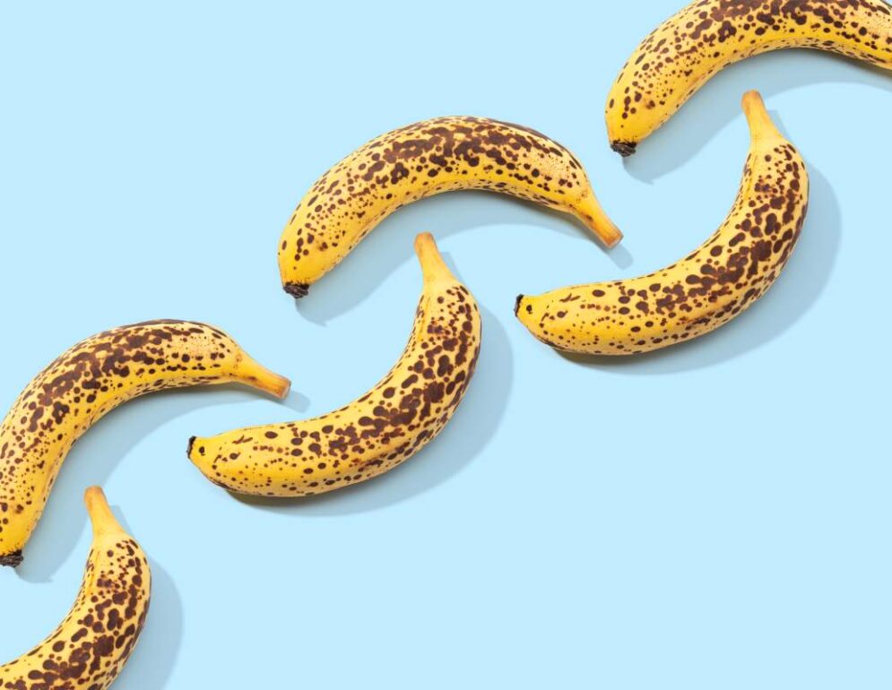 Spotted Banana pattern on blue background. Art food. Copy space